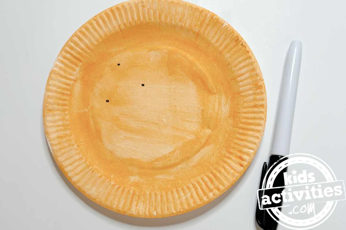 Étape 3 - Bricolage avec une assiette en papier orange - À l'aide du feutre, dessinez trois petits points pour ajouter une touche décorative - Blog d'activités pour enfants