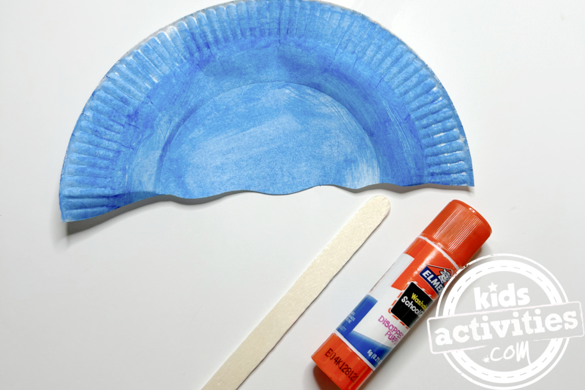 Étape 4 - Bricolage avec une assiette en carton avec un parapluie - Collez le bâtonnet de glace au dos de votre assiette en carton - Blog d'activités pour enfants