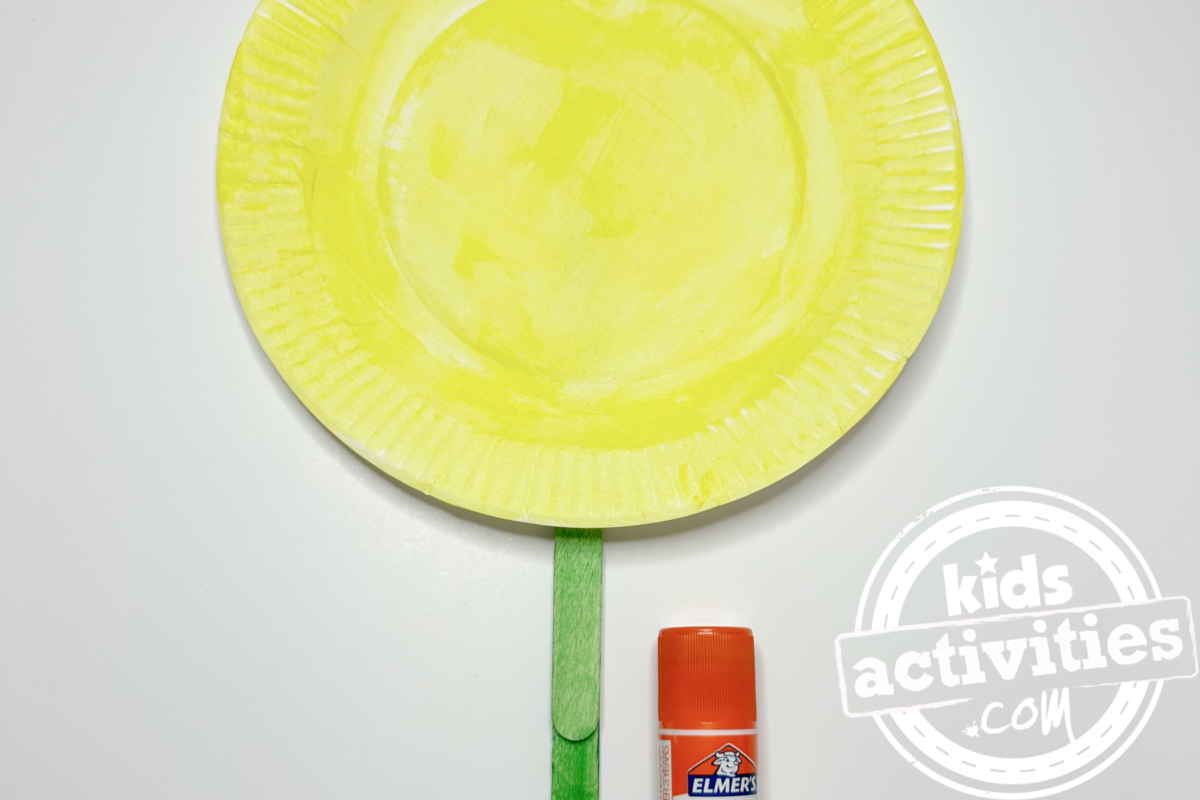 Étape 5 - Bricolage avec une assiette en carton de tournesol - Collez l'assiette en carton sur le bâton - Blog d'activités pour enfants