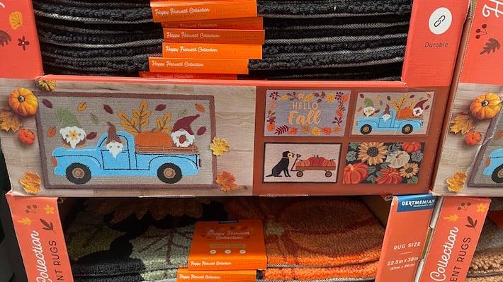 Tapis d'automne Costco - boîte en carton montrant 4 tapis différents - bonjour l'automne, camion bleu, chien et citrouilles, citrouilles et fleurs