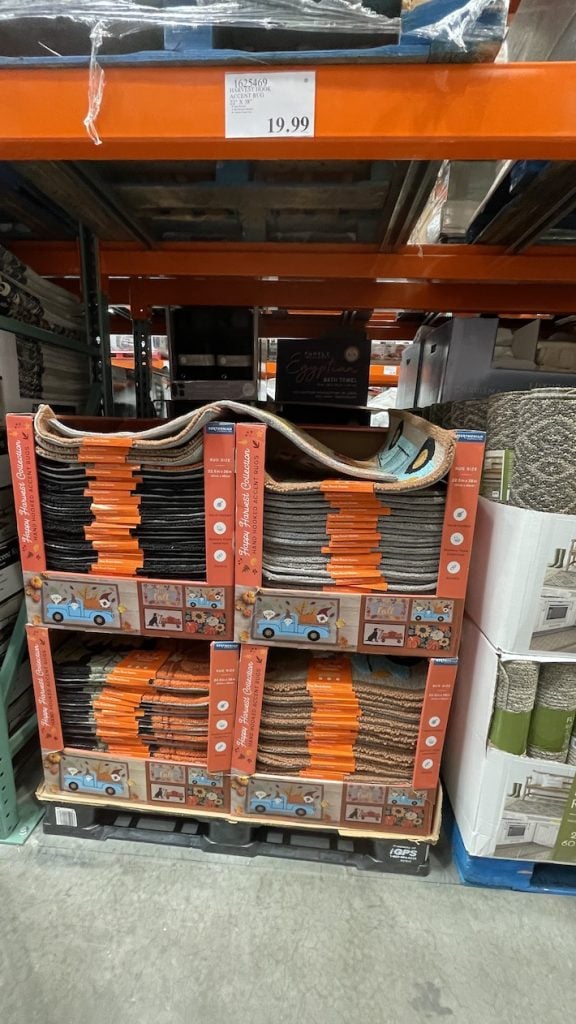 Plan éloigné des tapis d'automne de Costco - Piles de tapis chez Costco sur une palette avec une étiquette de prix supérieure à 19,99
