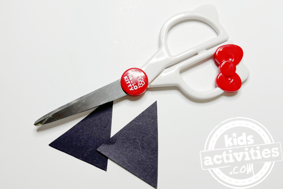 Étape 4 - Bricolage avec assiette en papier pour raton laveur - Découpez deux triangles avec du papier de construction noir - Blog d'activités pour enfants