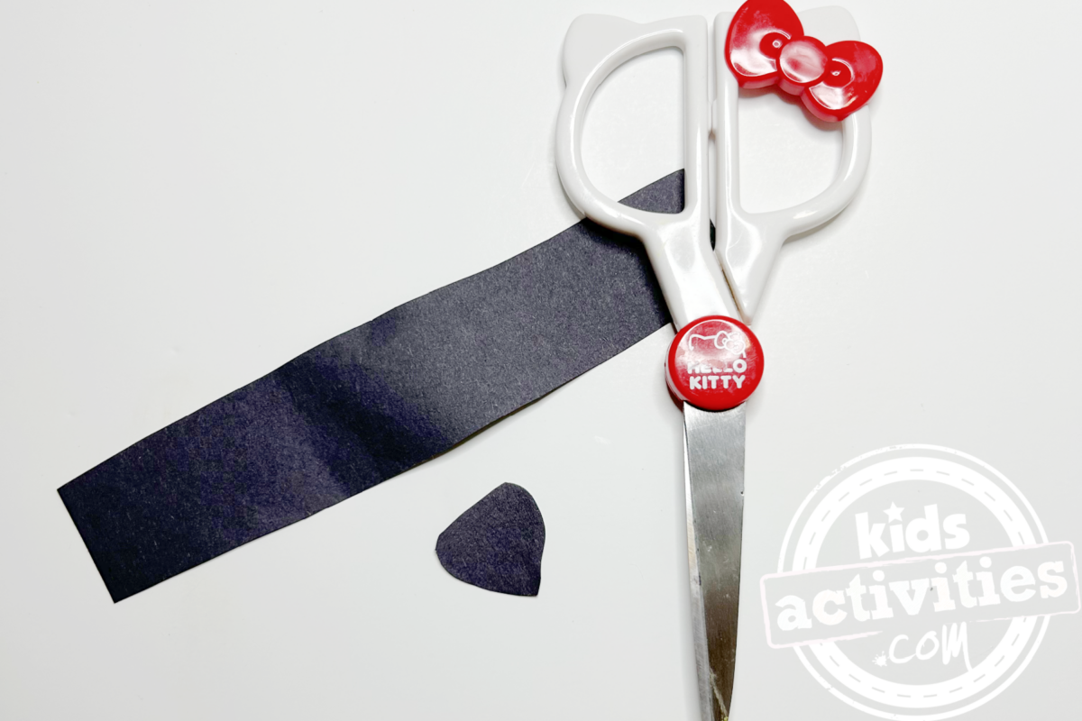 Étape 2 - Bricolage avec une assiette en papier en forme de raton laveur - Découpez une longue bande et un petit triangle avec le papier de construction noir - Blog d'activités pour enfants