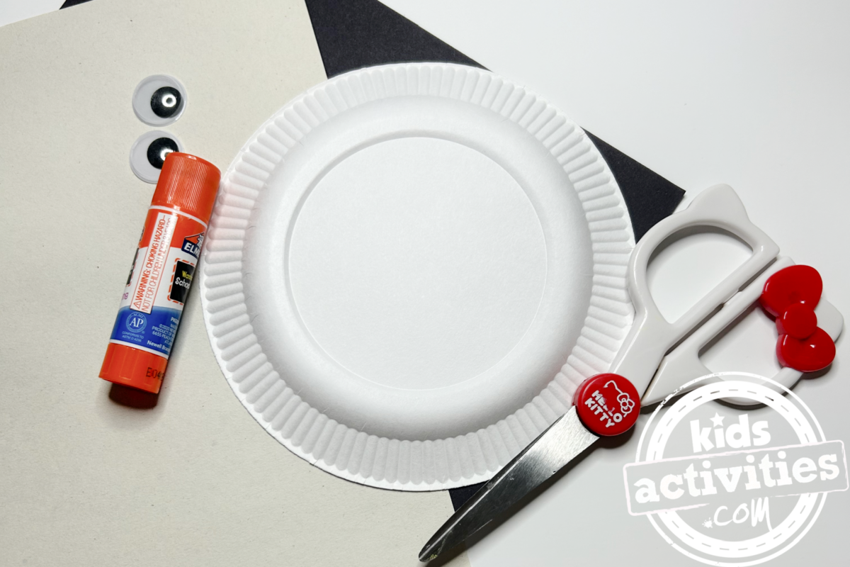 Fournitures nécessaires pour le bricolage avec une assiette en papier zèbre : une mini assiette en papier, du papier de construction noir et blanc, deux yeux mobiles, des ciseaux, de la colle - blog d'activités pour enfants