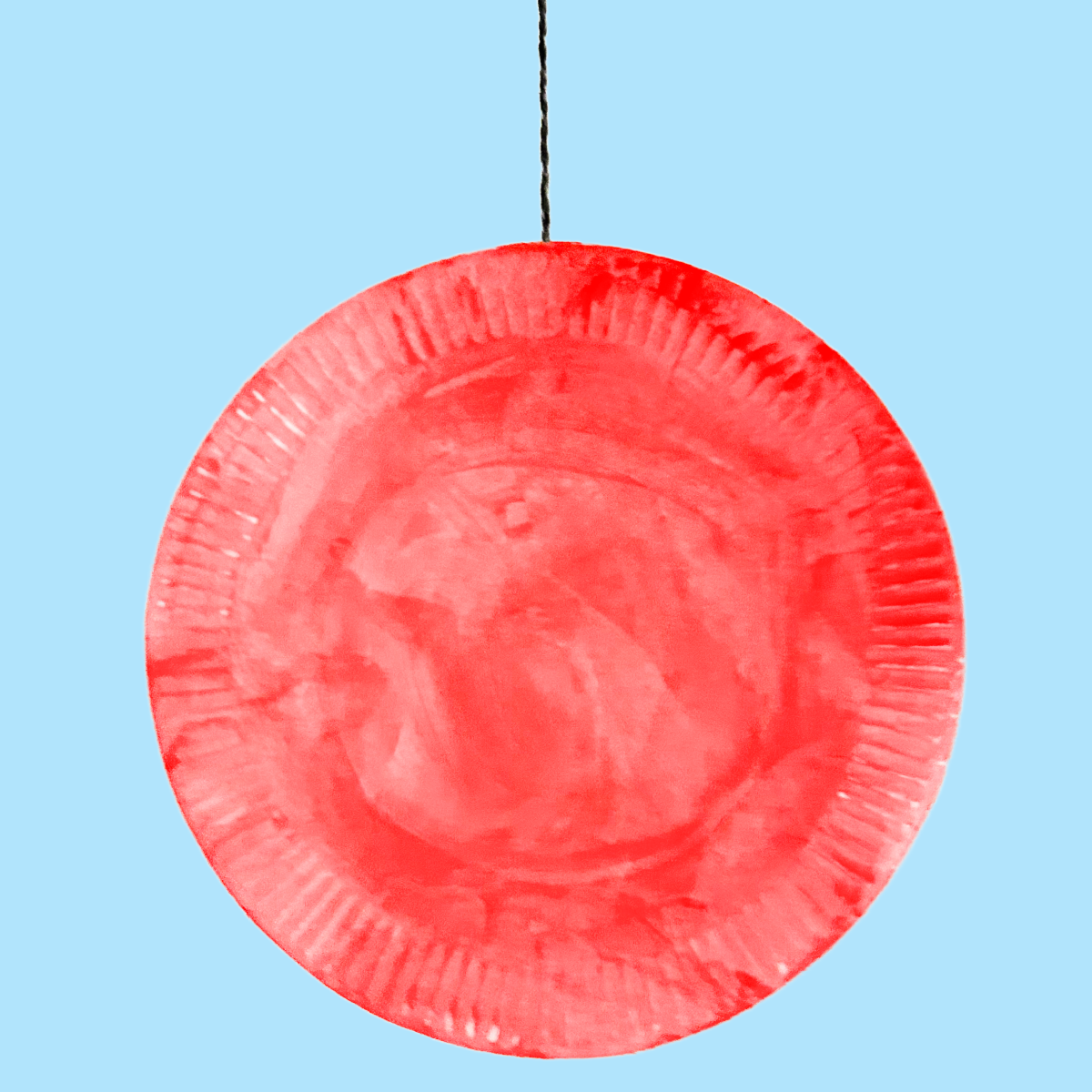 Yo-yo fini fabriqué à partir de 2 assiettes en carton suspendues à la ficelle de fil sur un fond bleu - Blog d'activités pour enfants