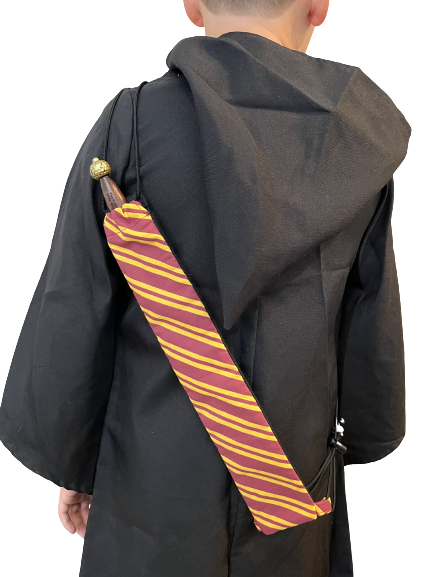 sac à baguette de sorcier pour enfants - enfant montré de dos avec un sac à dos en bandoulière tenant une seule baguette de sorcier