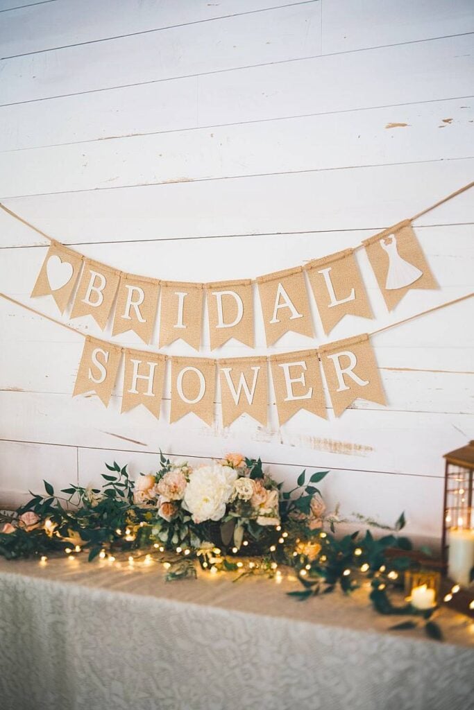 Bannière de douche nuptiale en toile de jute rustique avec des accents de table florale.
