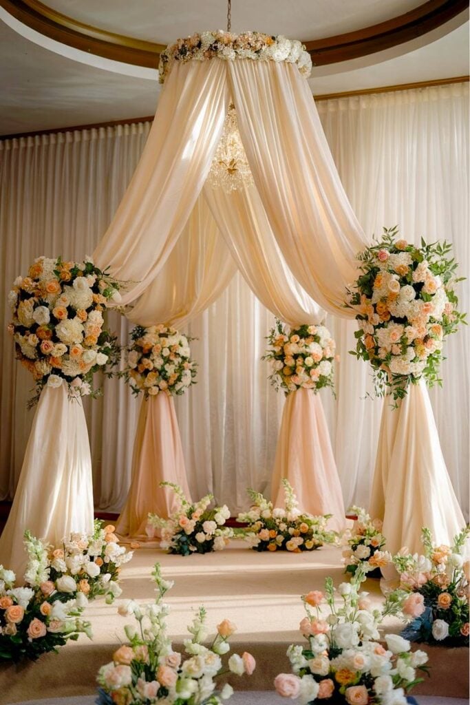 Arc de mariage floral de luxe avec roses et tissu drapé.