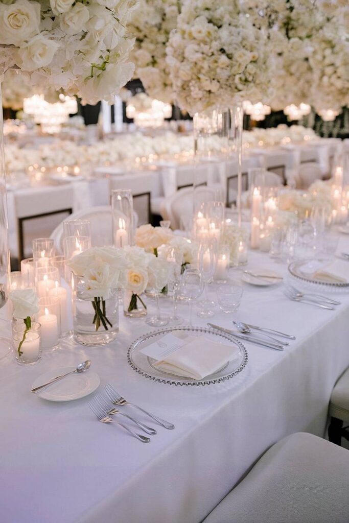 Pièce maîtresse de mariage de luxe extravagante avec des fleurs blanches et des bougies.