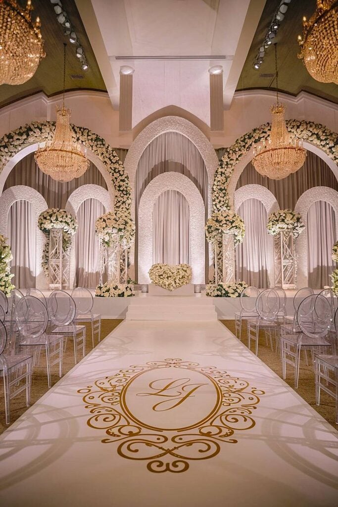 Toile de fond de mariage de luxe minimaliste avec arches florales et allée monogrammée.
