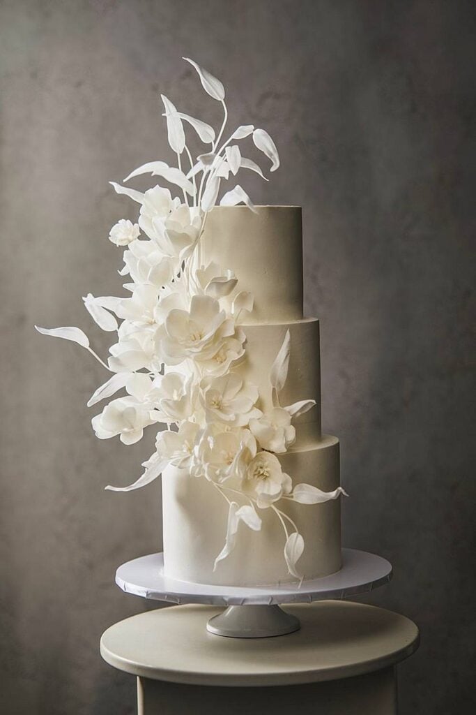 Gâteau de mariage de luxe époustouflant avec des fleurs en sucre en cascade.