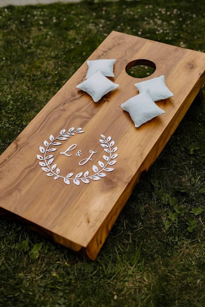 Jeu de cornhole en bois personnalisé avec des initiales pour un mariage dans la cour.