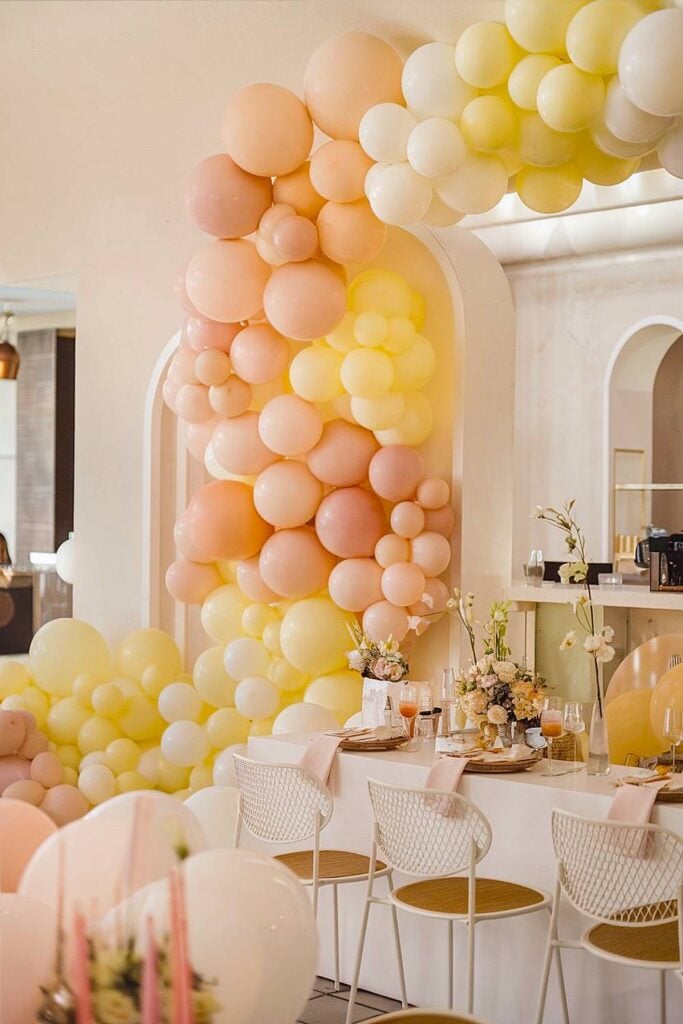 Décorations de ballons pastel et configuration de table pour une fête nuptiale élégante.