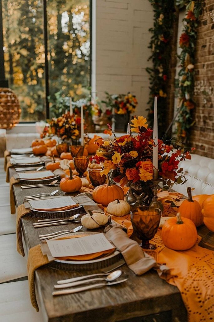 Table de fête de bachelorette sur le thème de l'automne avec des citrouilles et des bougies.