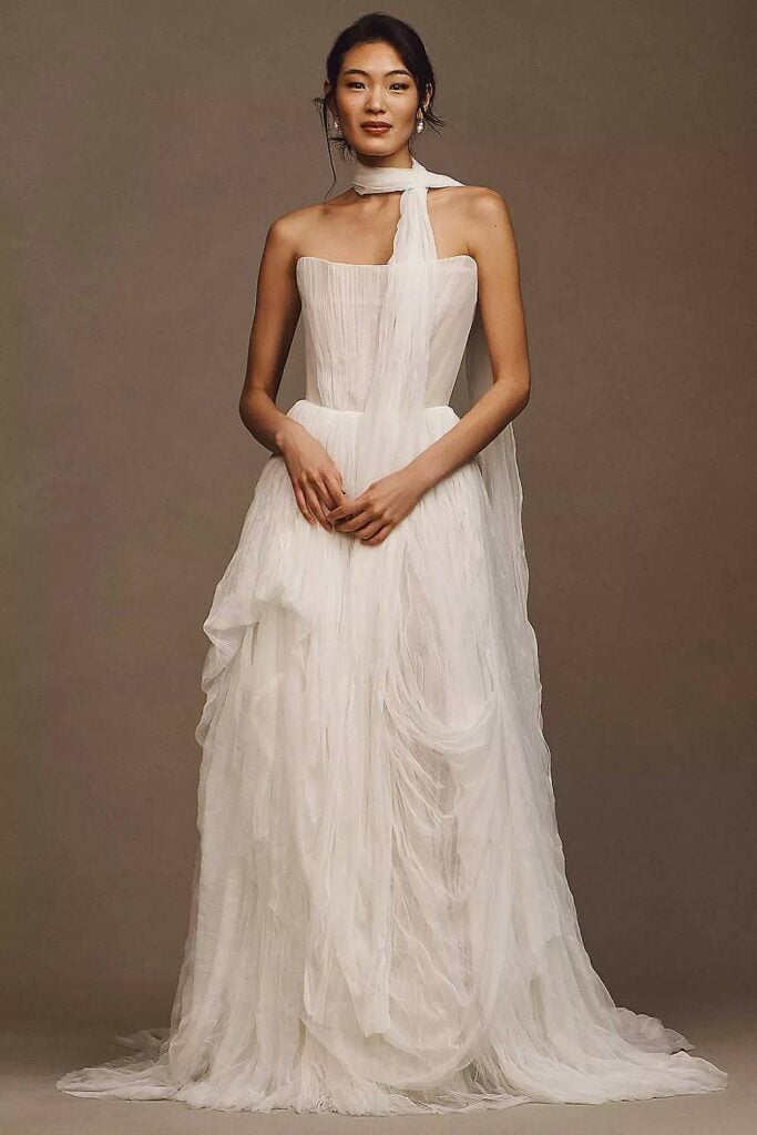 Robe de mariée simple corset avec corsage transparent et écharpe drapée.