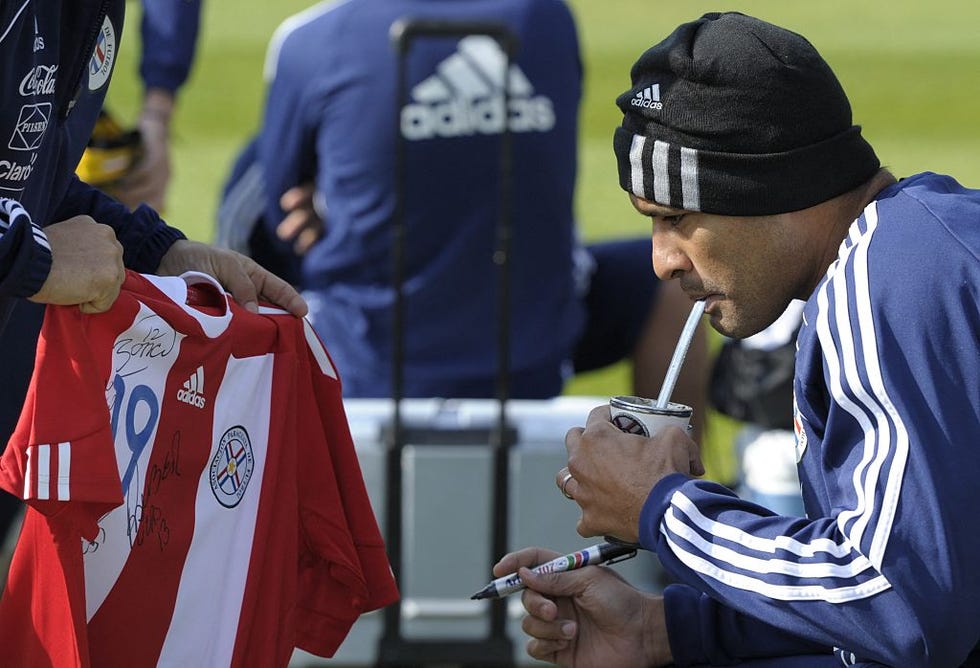 Le défenseur des Paraguays Paulo da Silva boit Terere (thé de compagnon de Yerba paraguayan typique préparé avec de l'eau froide) avant une séance d'entraînement à la Michaelhouse School à Balgowan le 11 juin 2010 avant la Coupe du monde de football 2010. AFP Photo / Juan Mabromata (Photo de Juan Mabromata / AFP) (Photo de Juan Mabromata / AFP via Getty Images)