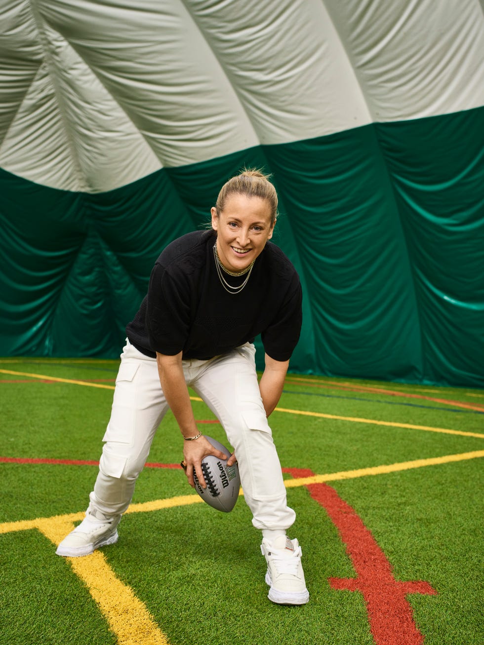 Personne se préparant à lancer un ballon de football sur un terrain de jeu intérieur vert.