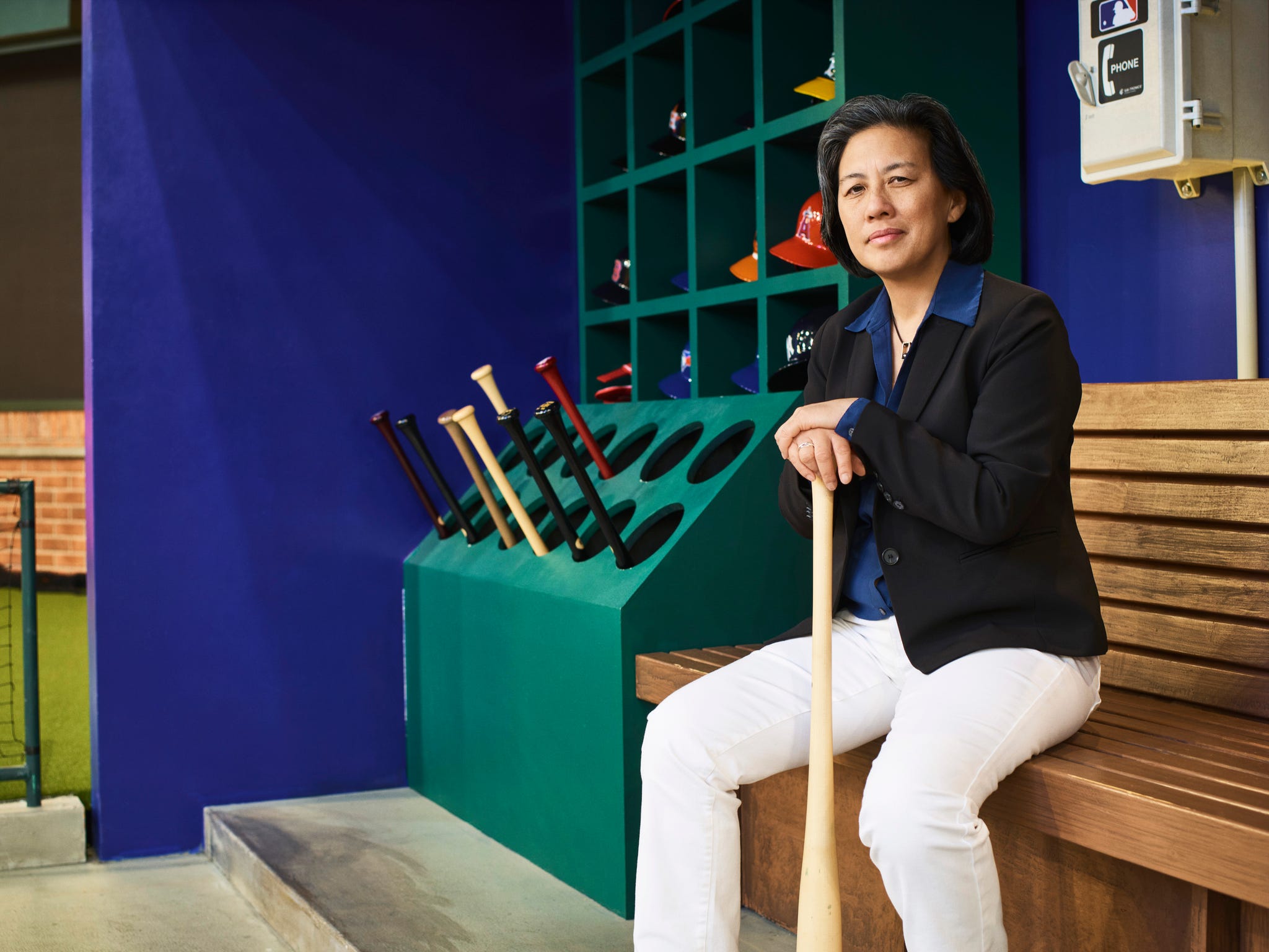 Personne assise avec une batte de baseball dans un environnement à thème sportif.