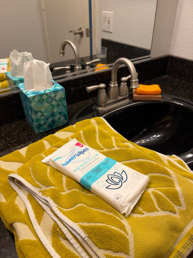 comptoir de salle de bain avec lingettes féminines et serviette