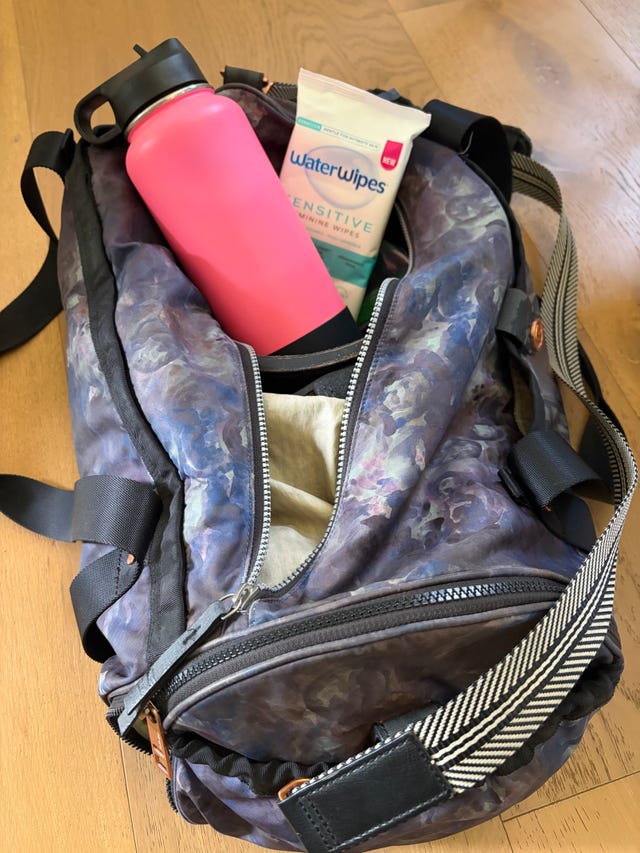 un sac avec une bouteille d'eau et des lingettes à l'intérieur